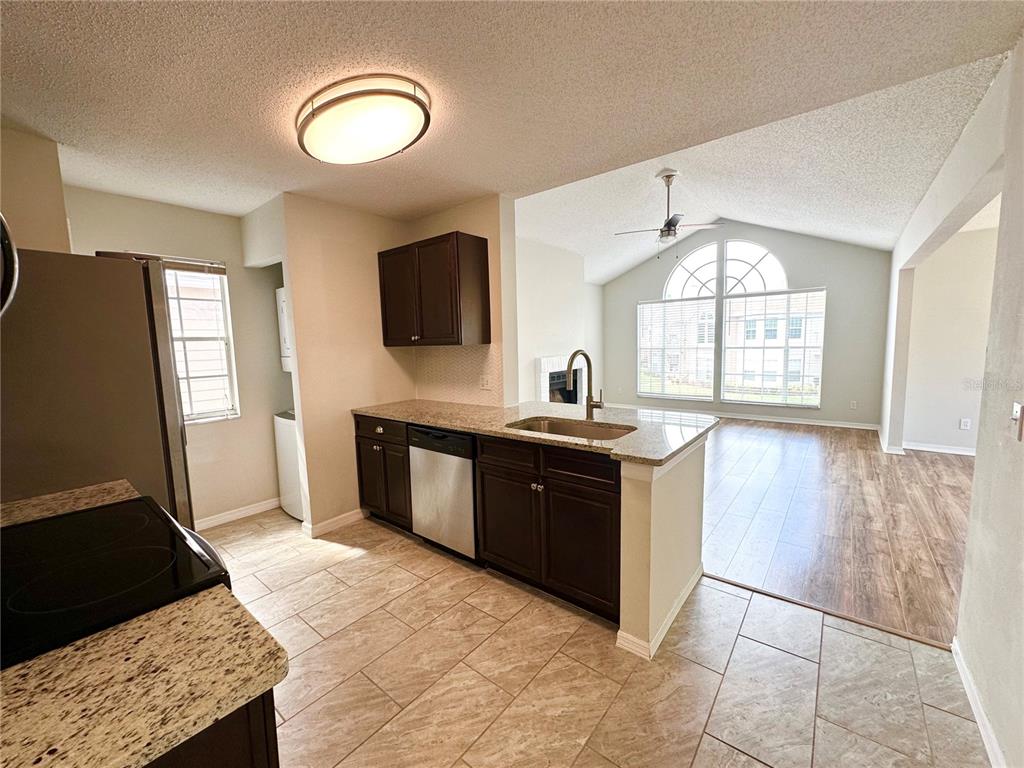 654 Roaring Drive, Unit 228 Altamonte Springs, FL 32714 - Photo 17 of 37 a large kitchen with a stove a sink a window and a counter top space