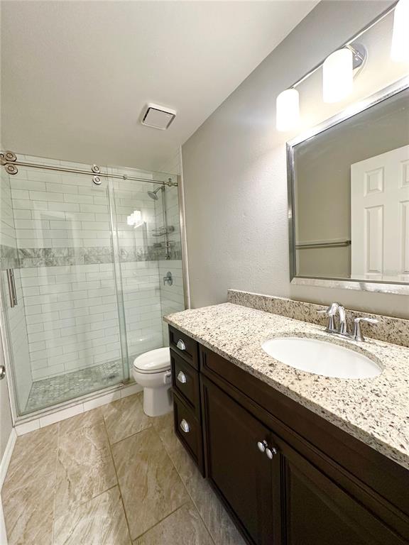 654 Roaring Drive, Unit 228 Altamonte Springs, FL 32714 - Photo 26 of 37 a bathroom with a granite countertop sink a toilet a mirror and shower