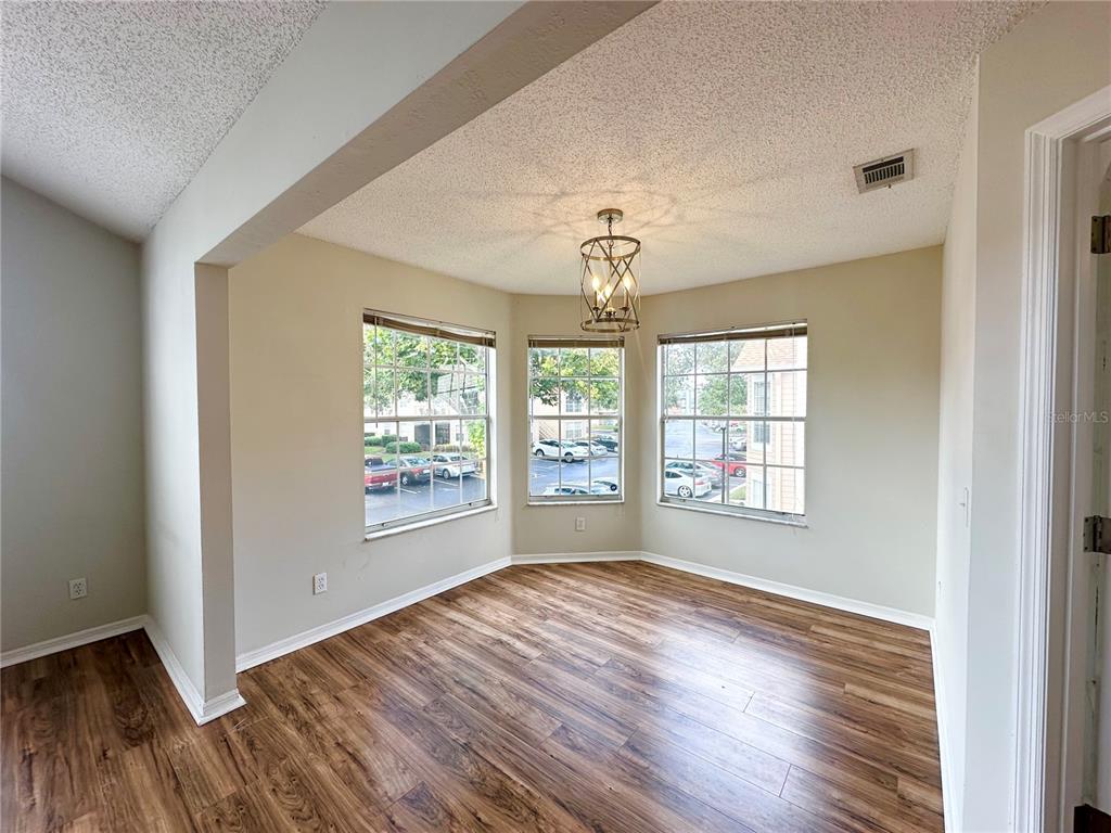 654 Roaring Drive, Unit 228 Altamonte Springs, FL 32714 - Photo 9 of 37 a view of an empty room with wooden floor and a window