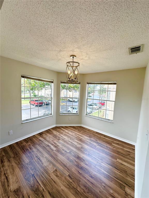 654 Roaring Drive, Unit 228 Altamonte Springs, FL 32714 - Photo 10 of 37 a view of an empty room with wooden floor and a window