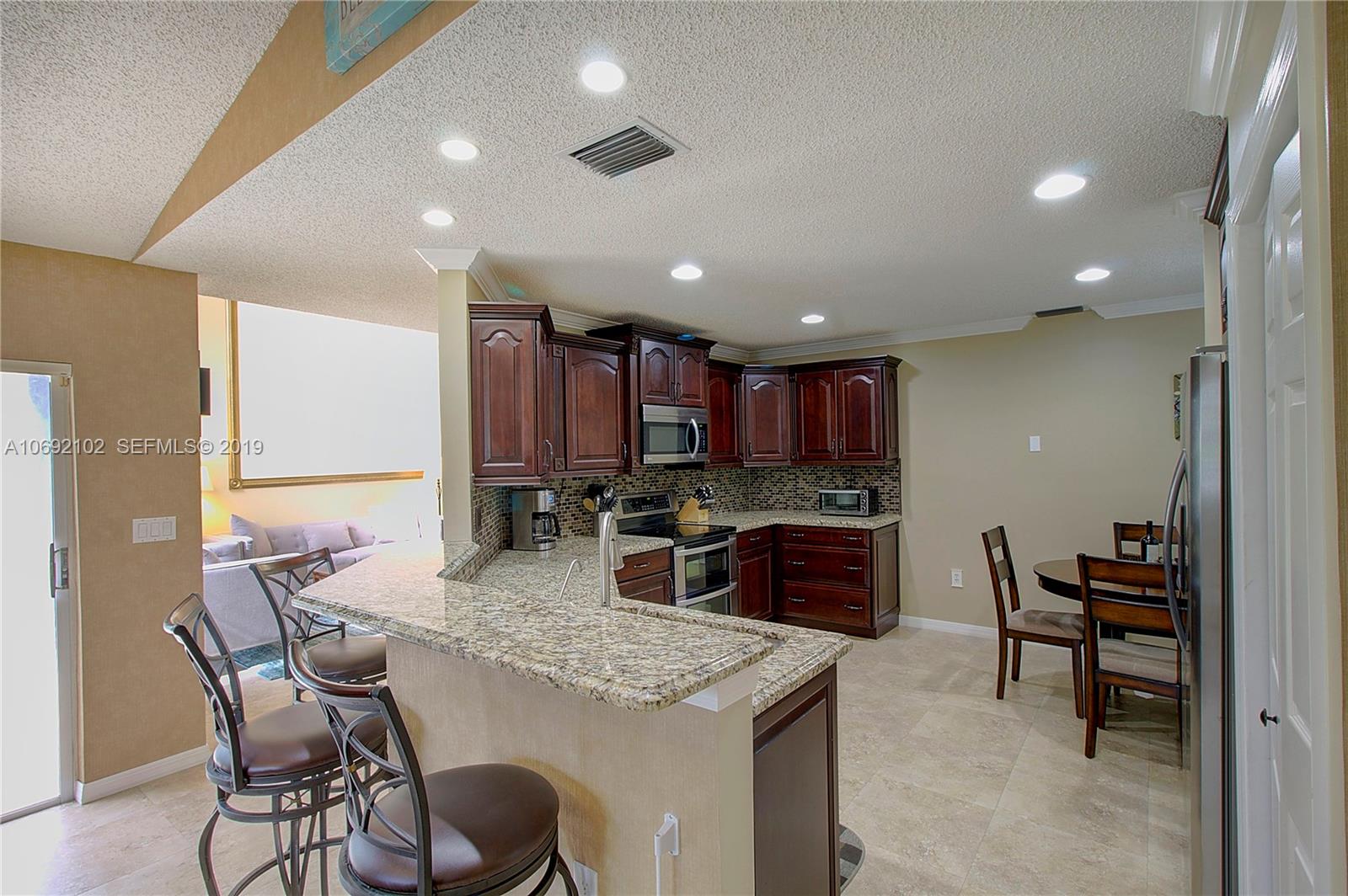 4113 Sapphire Bend Weston, FL 33331 - Photo 15 of 30 a kitchen with a table and chairs in it