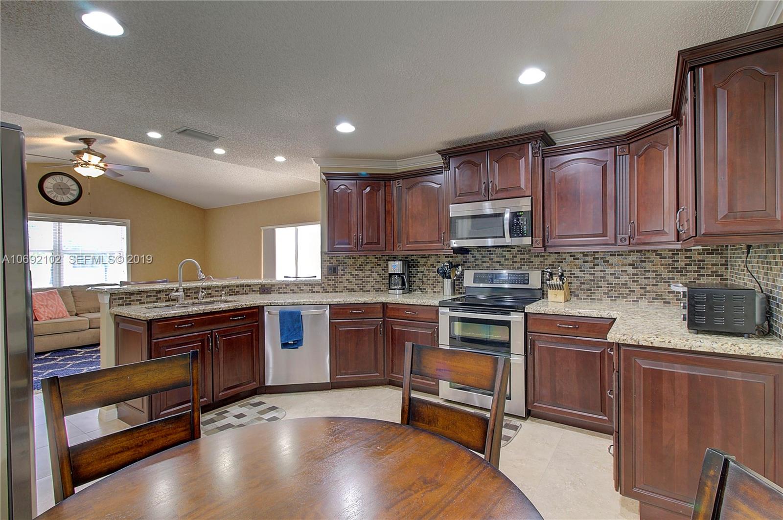 4113 Sapphire Bend Weston, FL 33331 - Photo 16 of 30 a kitchen with stainless steel appliances granite countertop a stove and a sink