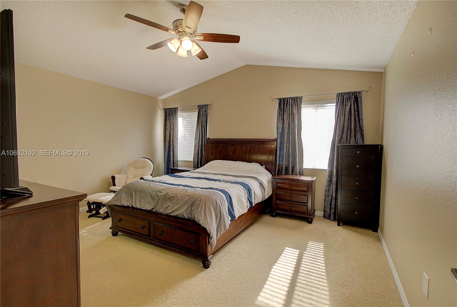 4113 Sapphire Bend Weston, FL 33331 - Photo 20 of 30 a spacious bedroom with a bed and a chandelier