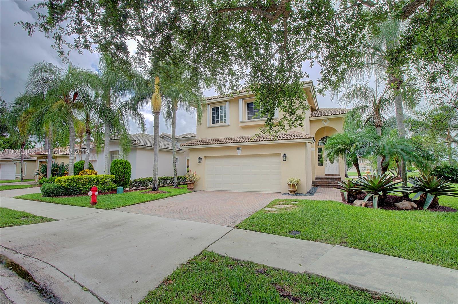 4113 Sapphire Bend Weston, FL 33331 - Photo 2 of 30 a front view of a house with a yard and garage