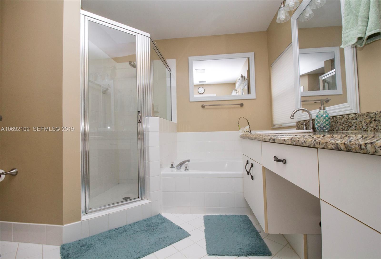 4113 Sapphire Bend Weston, FL 33331 - Photo 21 of 30 a bathroom with a granite countertop sink a mirror and a bathtub