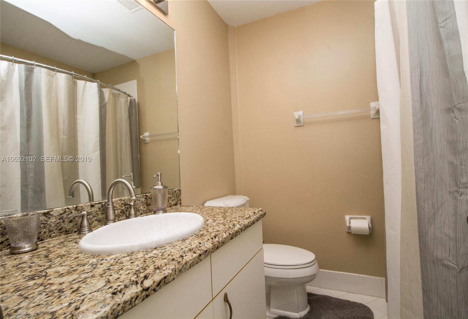 4113 Sapphire Bend Weston, FL 33331 - Photo 25 of 30 a bathroom with a granite countertop sink toilet and a mirror