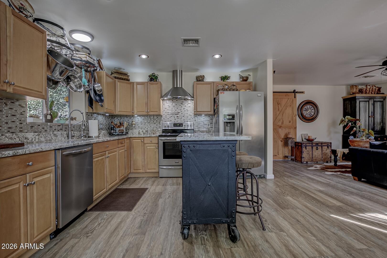 3762 Watertank Road Pine, AZ 85544 - Photo 10 of 38 a kitchen with stainless steel appliances kitchen island granite countertop a table chairs in it and wooden floors