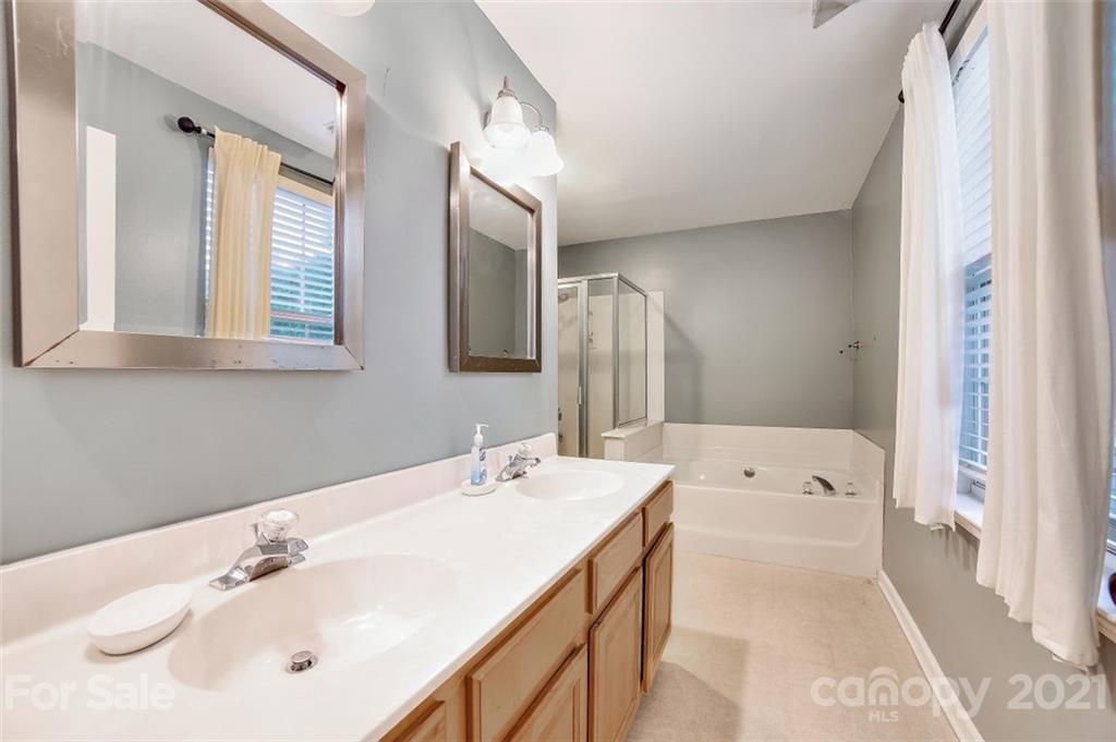 11145 Carver Pond Road Charlotte, NC 28269 - Photo 15 of 30 a bathroom with a tub sink and mirror