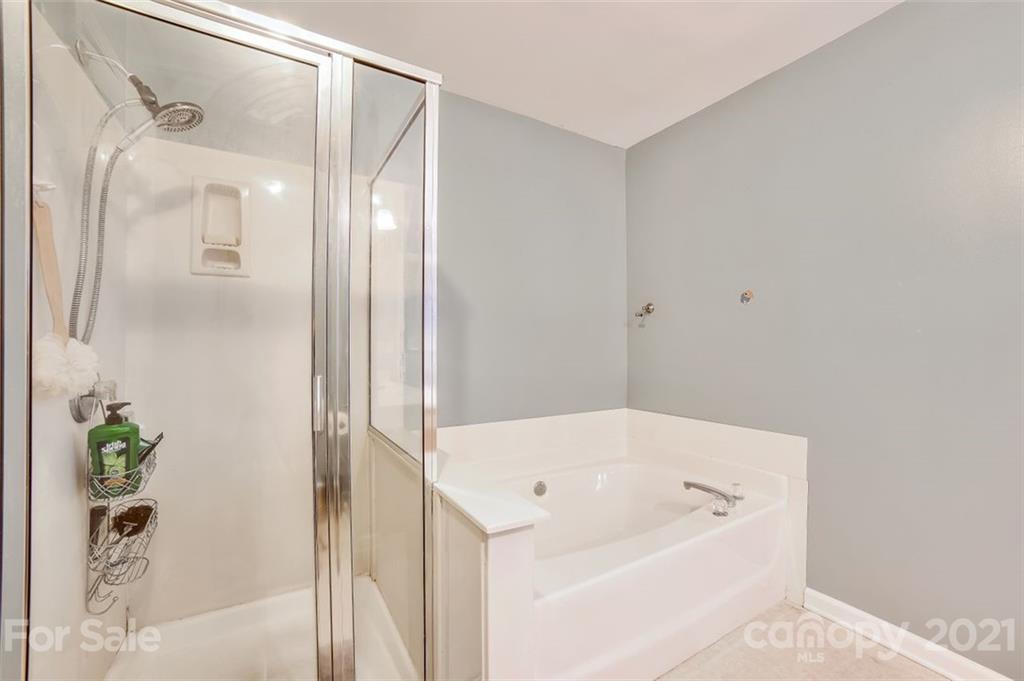 11145 Carver Pond Road Charlotte, NC 28269 - Photo 16 of 30 a bathroom with a bathtub and a shower