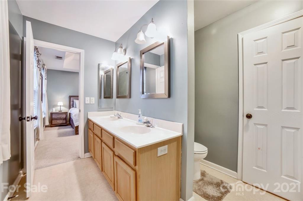 11145 Carver Pond Road Charlotte, NC 28269 - Photo 17 of 30 a bathroom with a sink a toilet and mirror