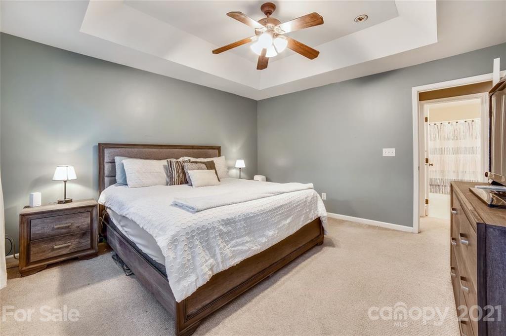 11145 Carver Pond Road Charlotte, NC 28269 - Photo 18 of 30 a bedroom with a bed and a chandelier