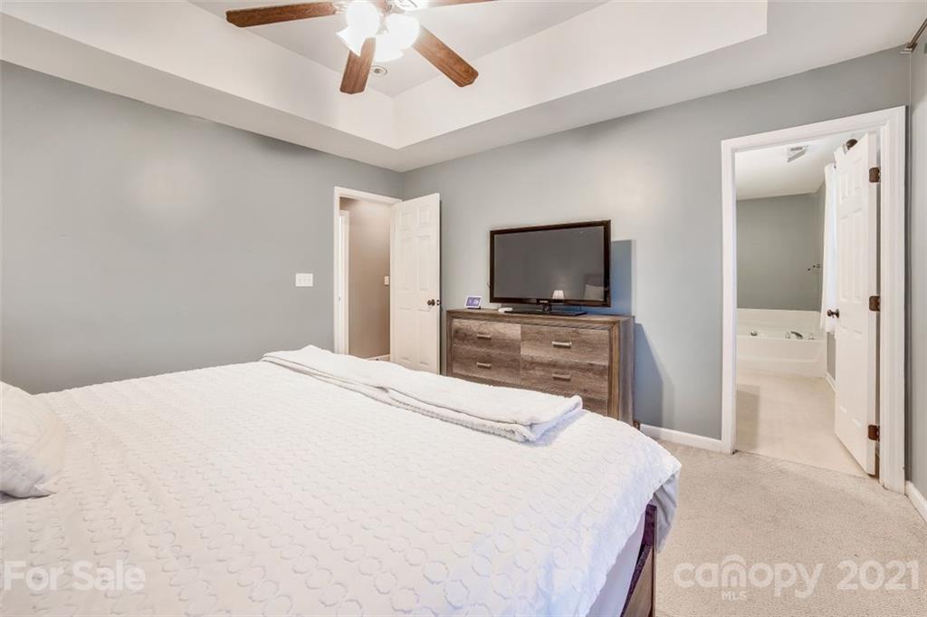 11145 Carver Pond Road Charlotte, NC 28269 - Photo 19 of 30 a bedroom with a bed and a flat screen tv