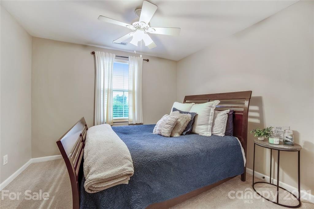 11145 Carver Pond Road Charlotte, NC 28269 - Photo 22 of 30 a bedroom with a bed and a chandelier