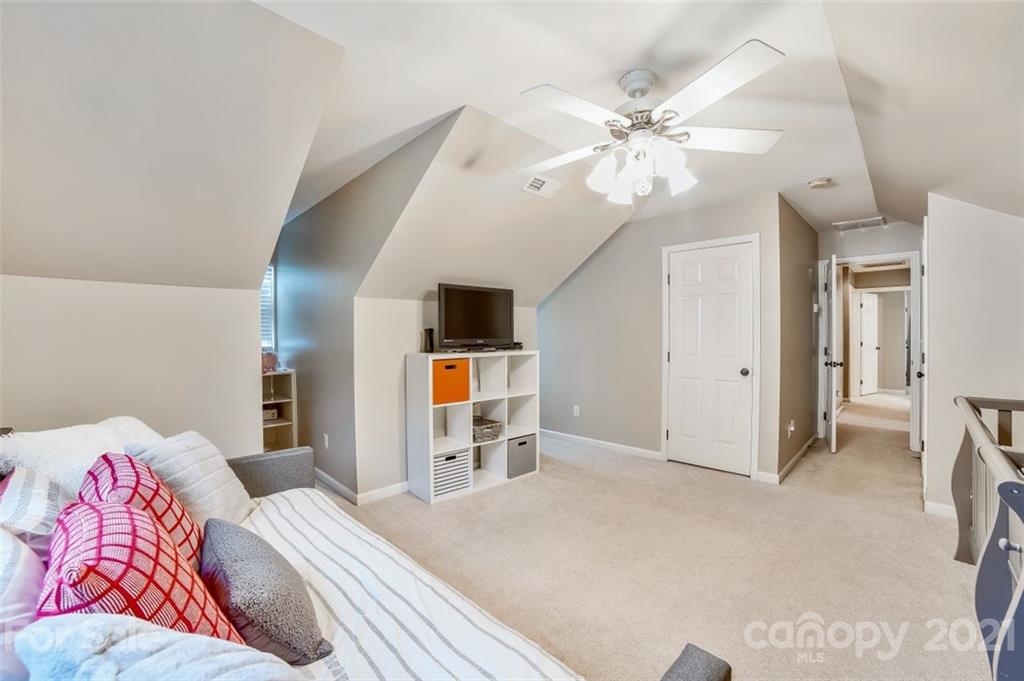 11145 Carver Pond Road Charlotte, NC 28269 - Photo 26 of 30 a bedroom with a bed and a chandelier