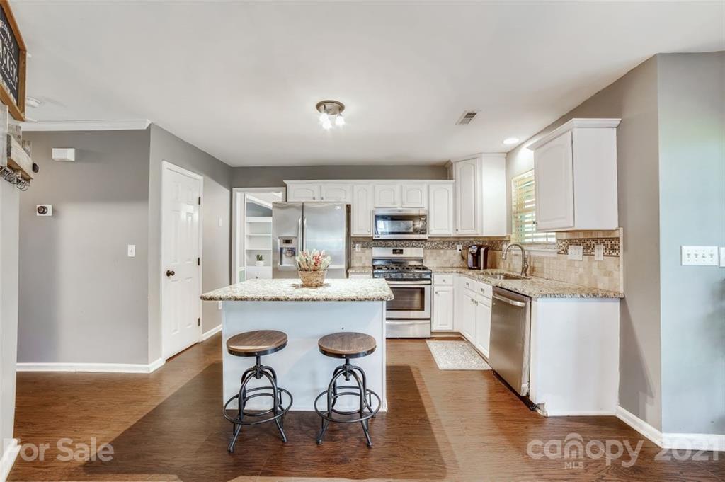 11145 Carver Pond Road Charlotte, NC 28269 - Photo 5 of 30 a kitchen with white cabinets and appliances