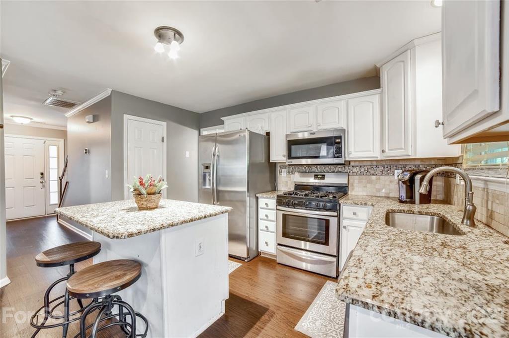 11145 Carver Pond Road Charlotte, NC 28269 - Photo 6 of 30 a kitchen with granite countertop stainless steel appliances a stove sink microwave and cabinets