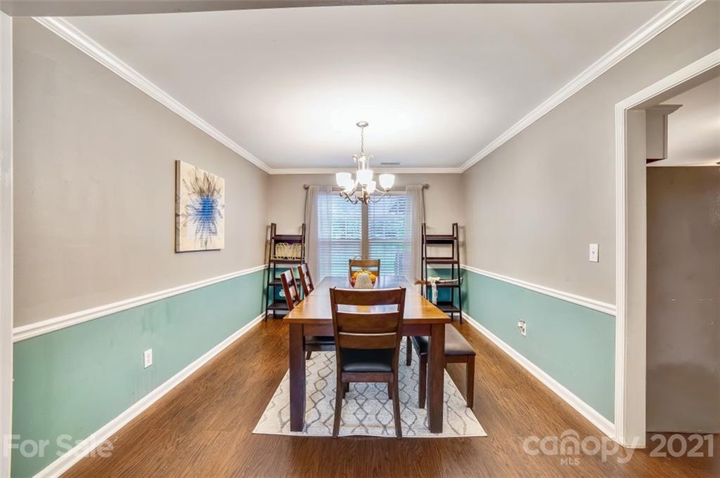 11145 Carver Pond Road Charlotte, NC 28269 - Photo 10 of 30 a living room with furniture and a chandelier