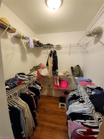 a view of walk in closet with clothes and shoes