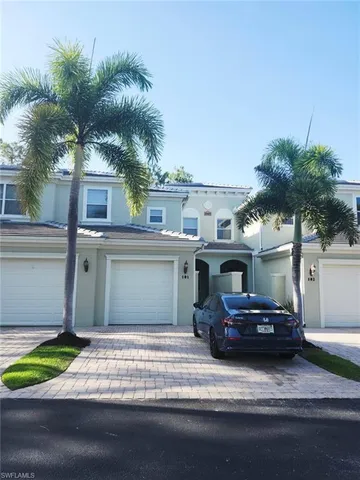 a front view of a house with a garden and parking