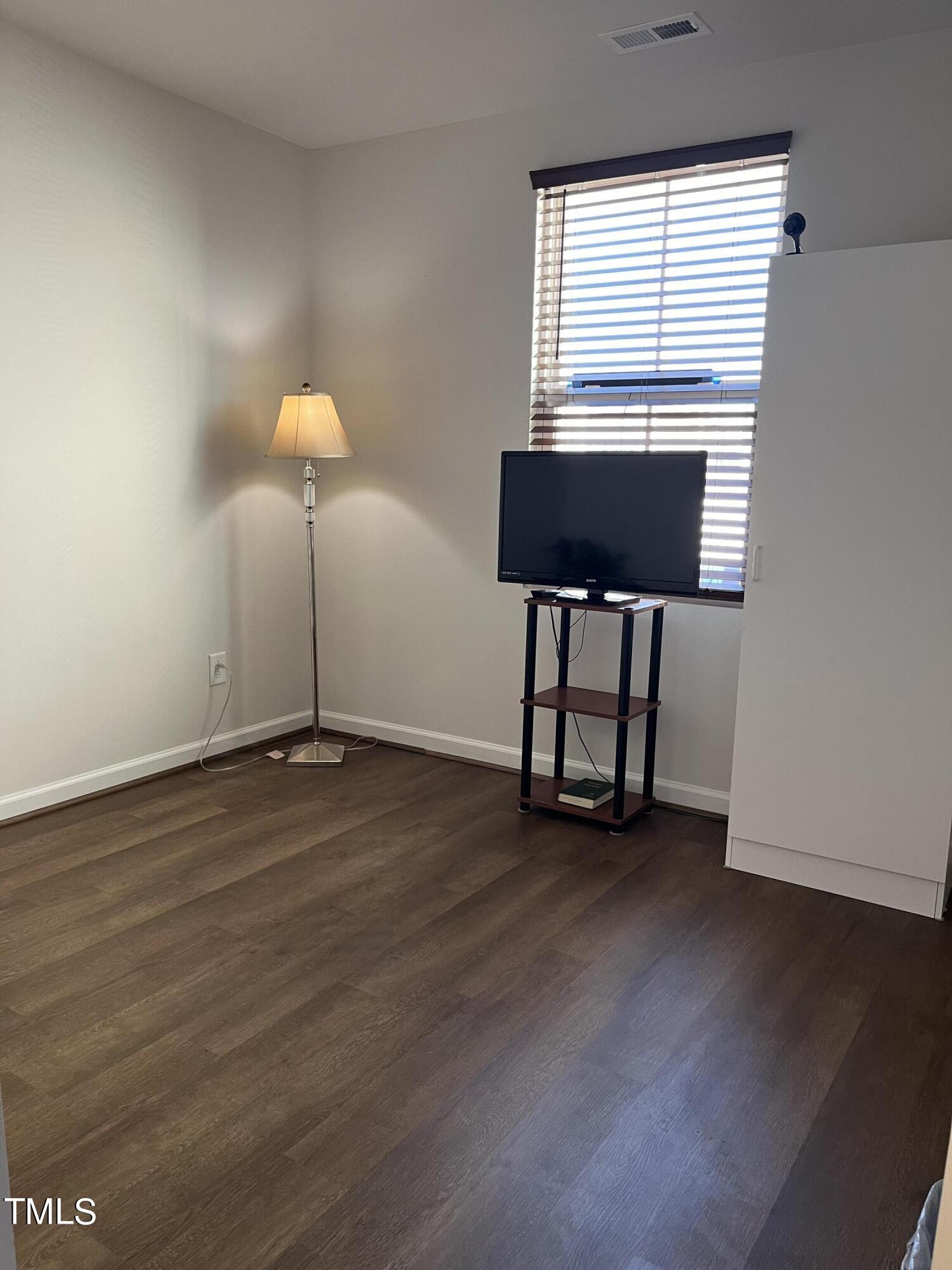 1408 Bridgewater Drive Durham, NC 27704 - Photo 14 of 41 a view of an empty room with a window and wooden floor