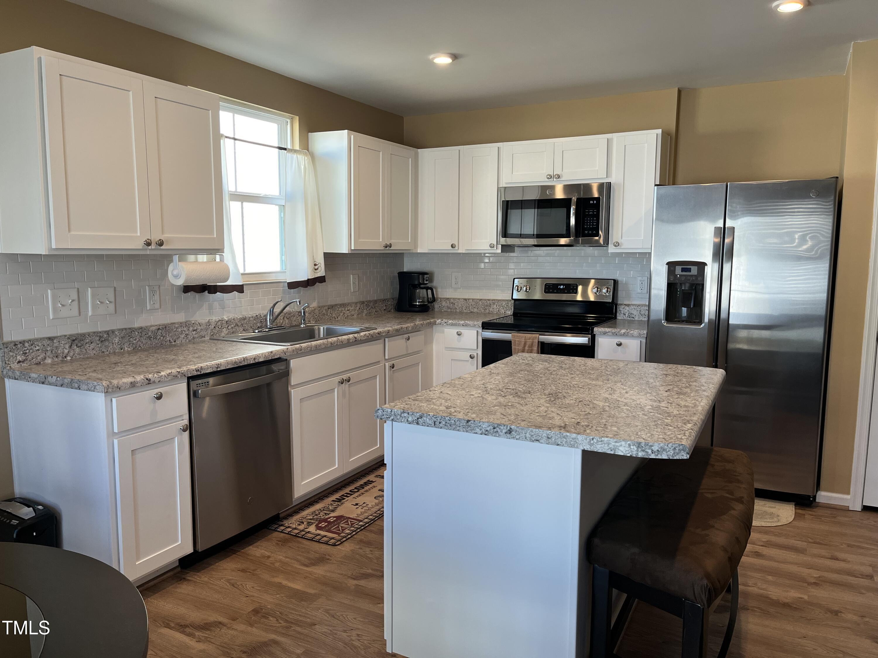 1408 Bridgewater Drive Durham, NC 27704 - Photo 30 of 41 a kitchen with stainless steel appliances granite countertop a stove a sink a microwave a refrigerator and white cabinets