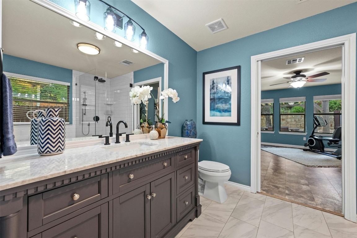 166 Briarpatch Court Austin, TX 78737 - Photo 20 of 40 a spacious bathroom with a granite countertop sink a toilet a mirror and shower