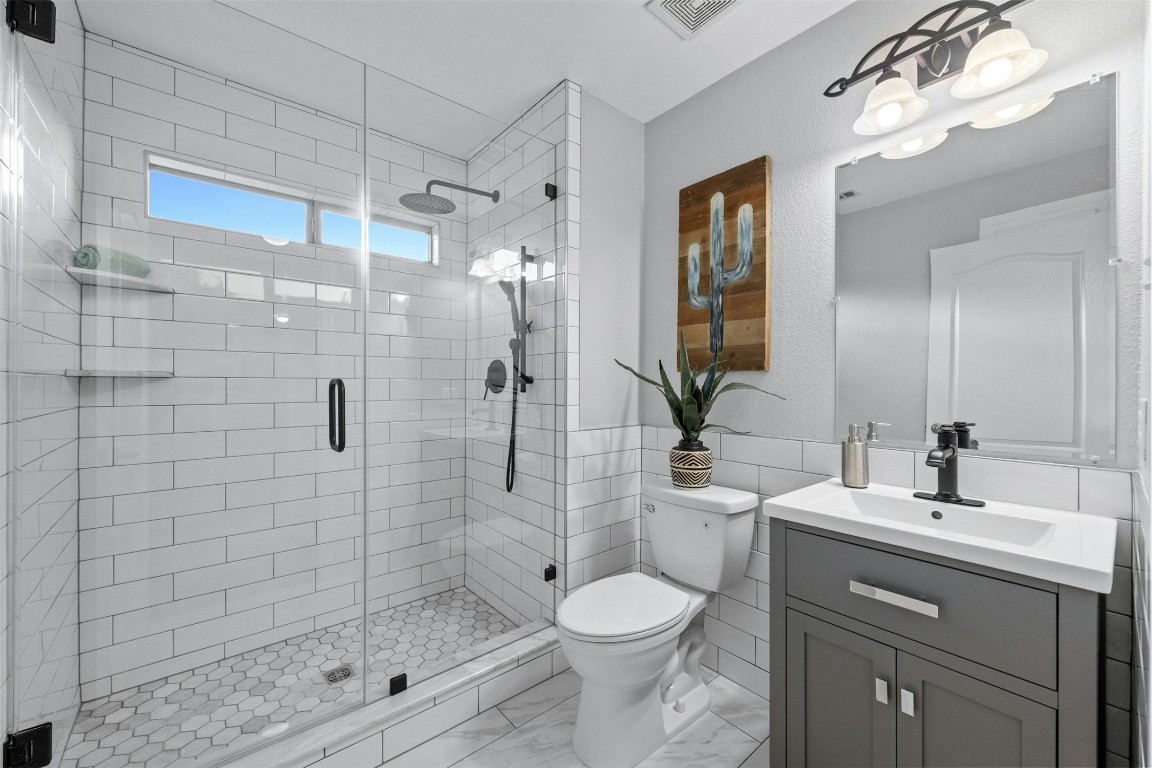 166 Briarpatch Court Austin, TX 78737 - Photo 24 of 40 a bathroom with a shower a sink a toilet and mirror