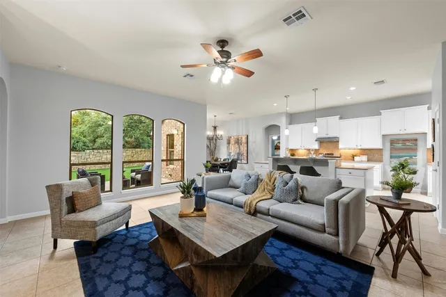 a living room with furniture kitchen view and a large window
