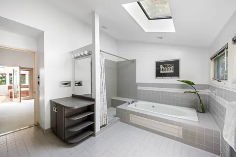 a spacious bathroom with a tub double vanity and shower