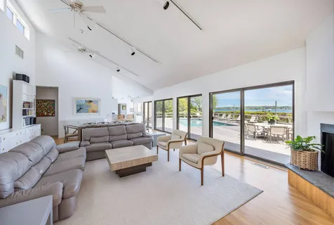 a living room with furniture and a large window with balcony view
