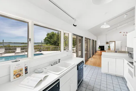 a large white kitchen with a large window
