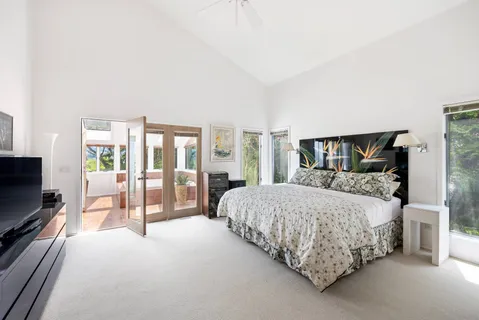 a bedroom with a large bed and a flat tv screen