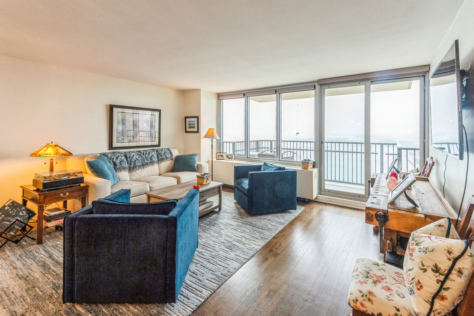 400 East Randolph Street, Unit 3209 Chicago, IL 60601 - Photo 4 of 59 a living room with furniture a flat screen tv and a floor to ceiling window