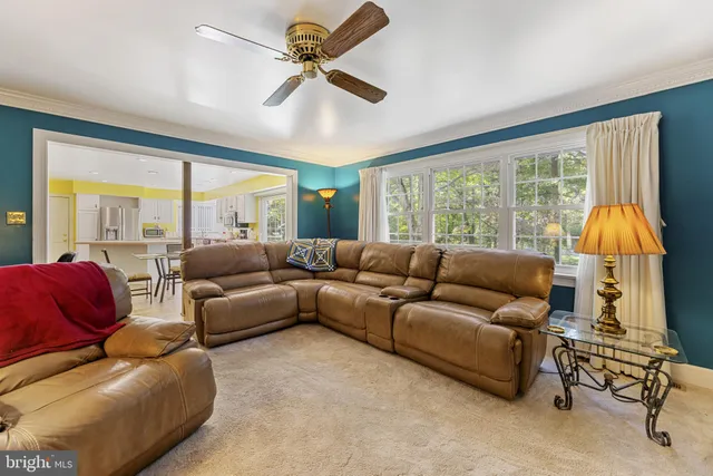 a living room with furniture a large window and a chandelier