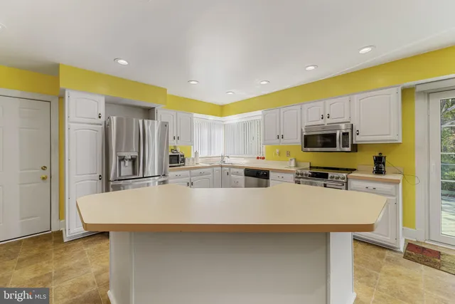 a large kitchen with a large counter top appliances and cabinets