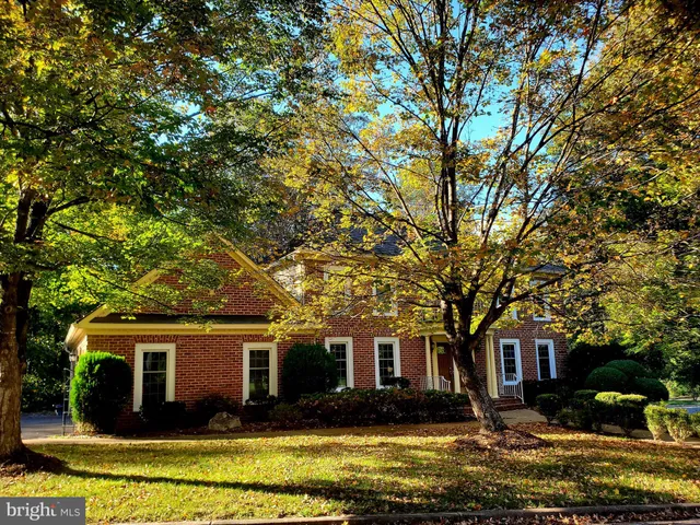 a front view of house with yard and trees in the background