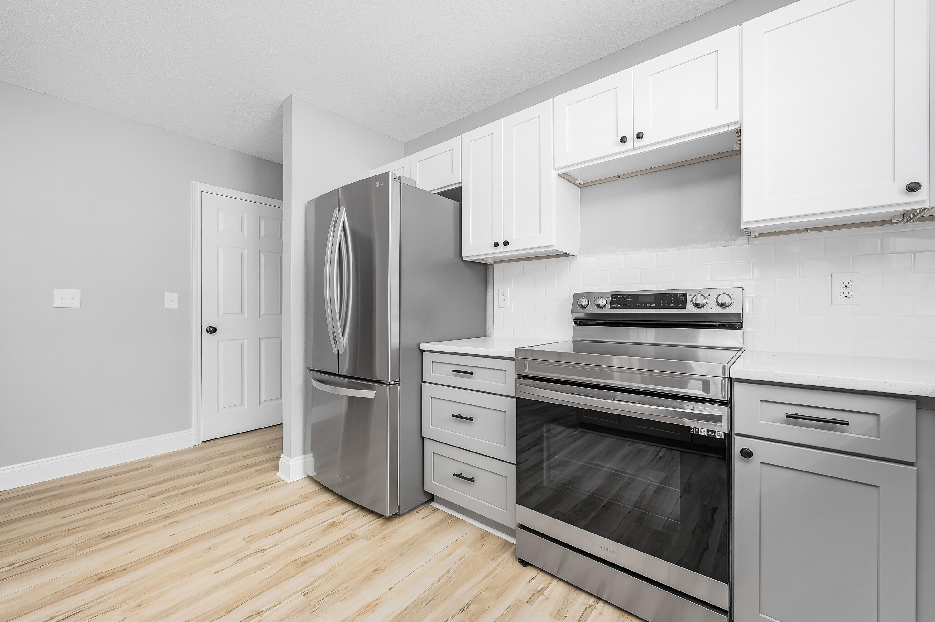 4622 Dove Way Crestview, FL 32539 - Photo 13 of 39 a kitchen with white cabinets stainless steel appliances and wooden floor