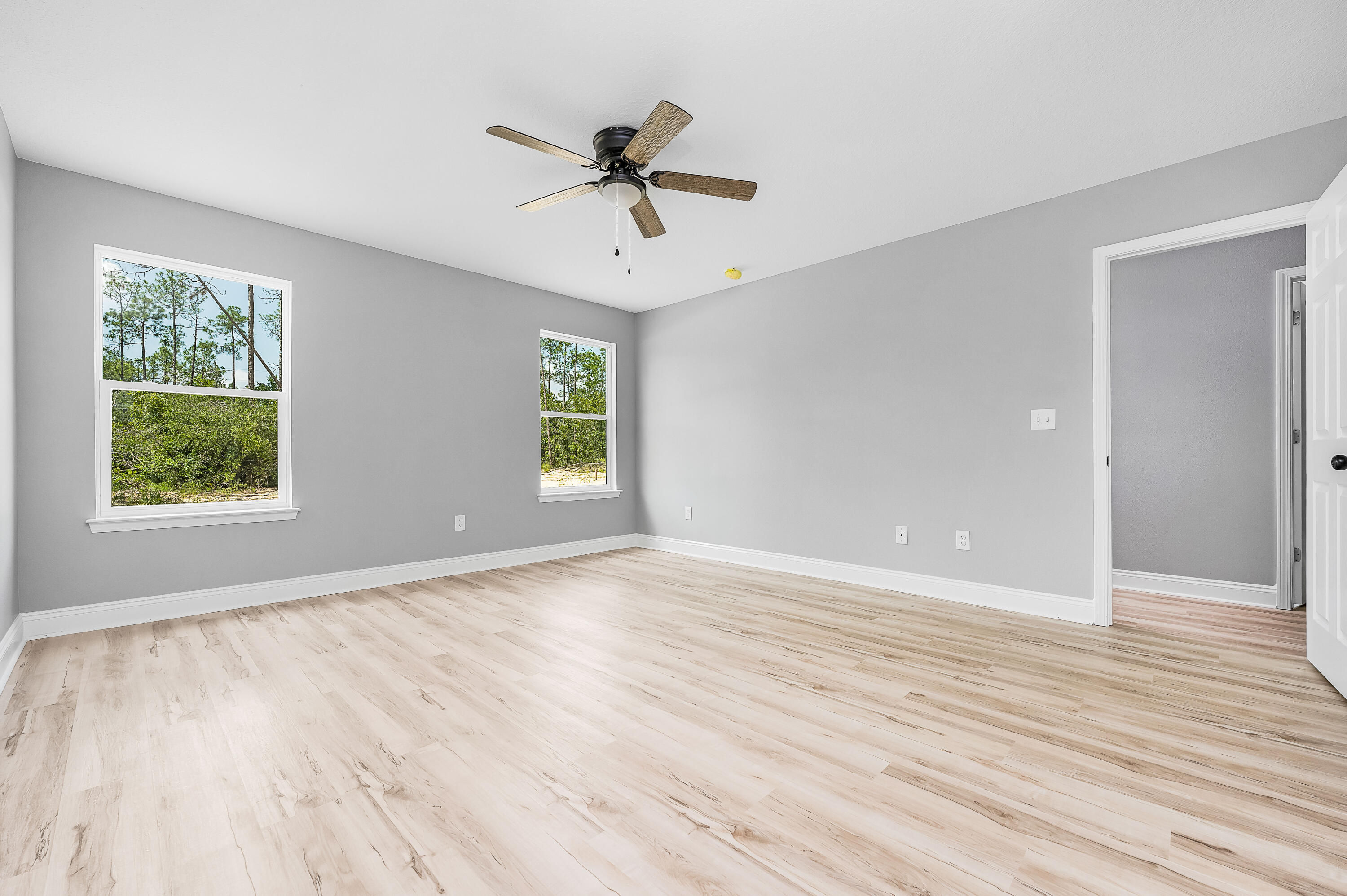 4622 Dove Way Crestview, FL 32539 - Photo 22 of 39 a view of an empty room with wooden floor and a window
