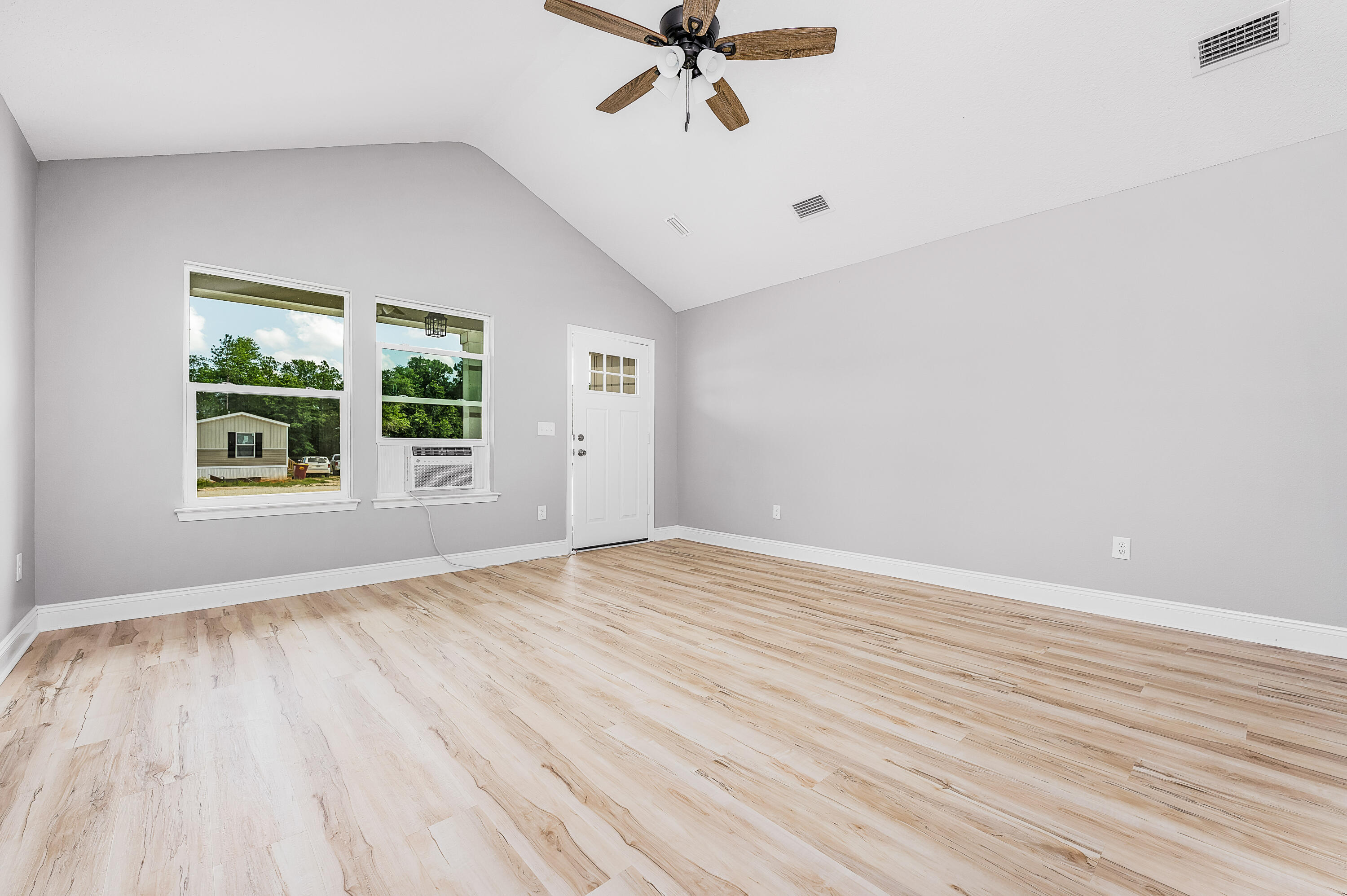 4622 Dove Way Crestview, FL 32539 - Photo 7 of 39 wooden floor in an empty room with a window