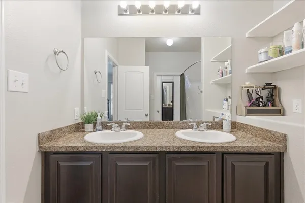 a bathroom with double sink and a mirror
