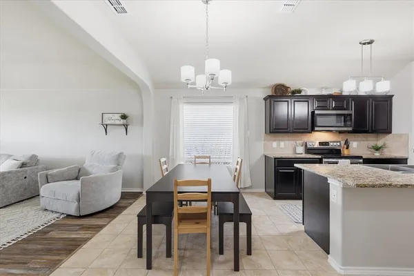a kitchen with furniture wooden floor and a chandelier