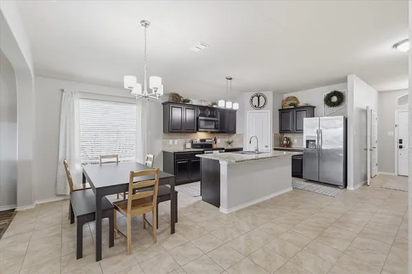 a kitchen with refrigerator and chairs