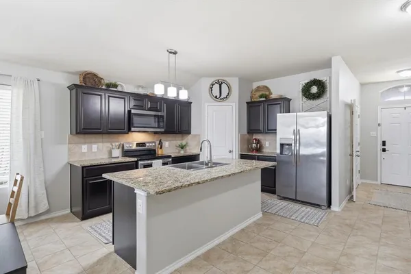 a kitchen with stainless steel appliances granite countertop a refrigerator stove a sink dishwasher and microwave oven