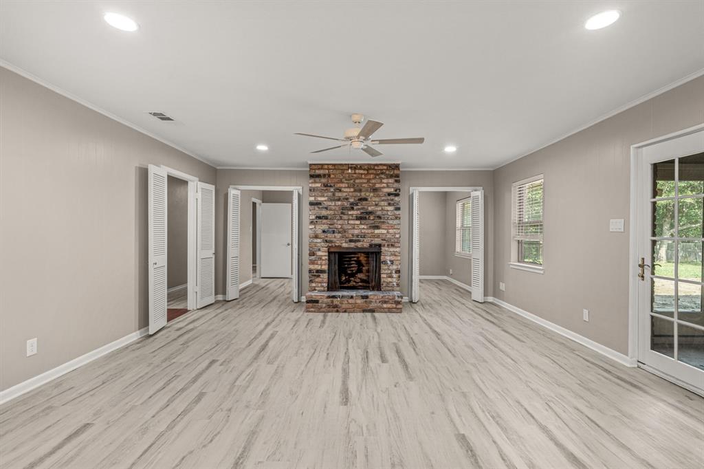 2216 Archer Trail Denton, TX 76209 - Photo 11 of 26 a view of an empty room with wooden floor fireplace and a window