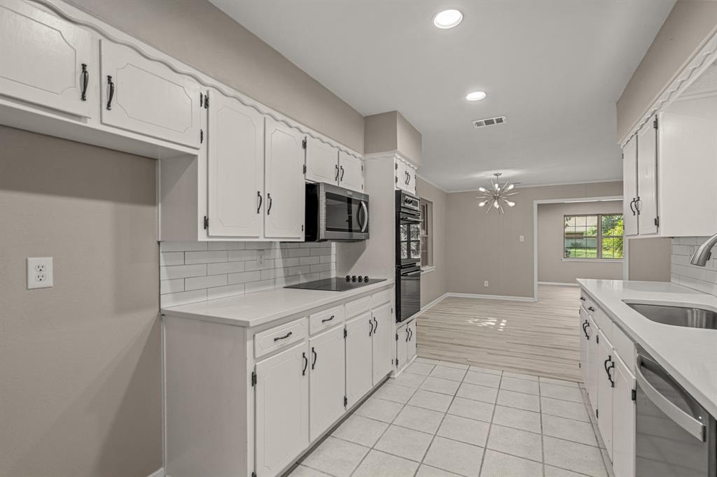 2216 Archer Trail Denton, TX 76209 - Photo 14 of 26 a kitchen with white cabinets appliances and sink