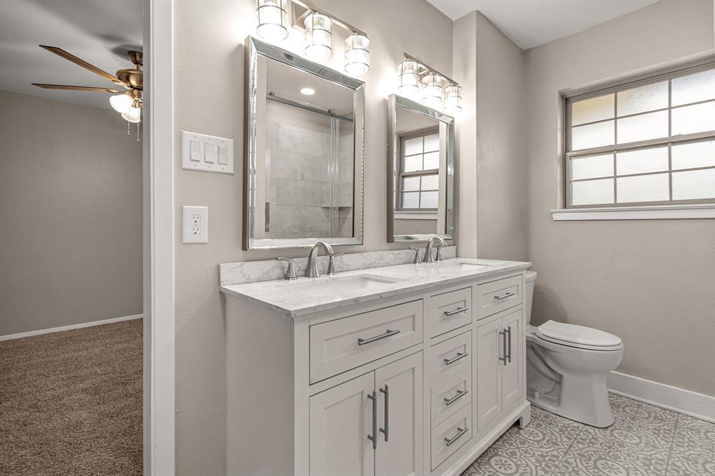 2216 Archer Trail Denton, TX 76209 - Photo 23 of 26 a bathroom with a double vanity sink a toilet and a mirror