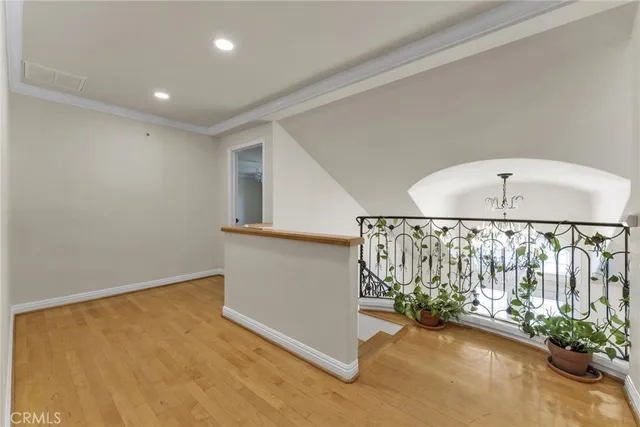a view of empty room with wooden floor and windows