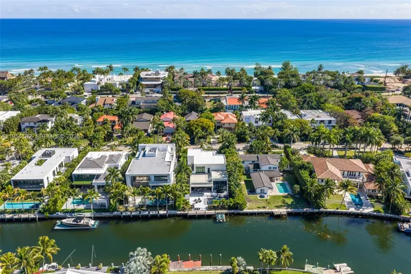 a large white kitchen with a large island in the center