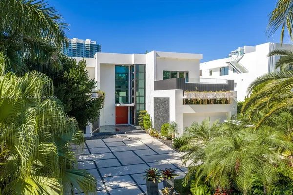 a kitchen with stainless steel appliances lots of white furniture a sink a stove a refrigerator with white cabinets and wooden floor