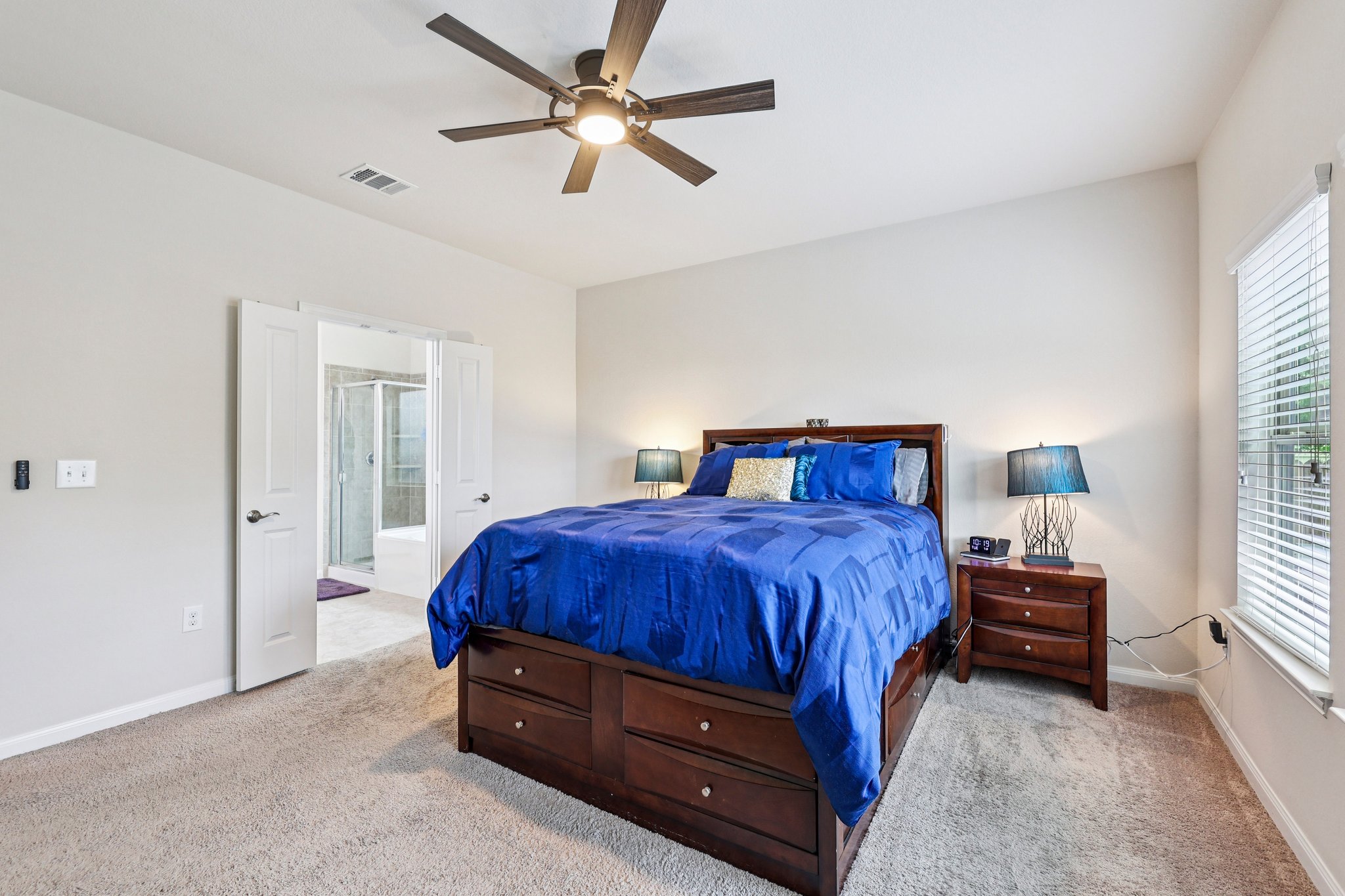 10033 Gertrudis Loop Austin, TX 78747 - Photo 18 of 39 This bedroom features neutral-toned walls, carpeting, and a ceiling fan with integrated lighting